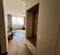 Novostavba FUXOVA 2 izbový byt, parking, Bosákova ul., BA V. Petržalka - Chodba v 2-izbovom byte s podlahou s dreveným dekorom a svetlým nábytkom.