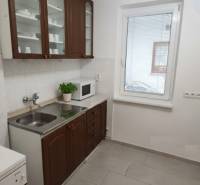 Na predaj: 2-izbový byt v centre mesta Galanta – časť Nová Doba - Kuchyňa 2-izbového bytu s tmavým nábytkom, spotrebičmi a svetlou dlažbou.