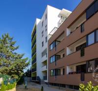 ŠPIČKOVO KOMPLETNE ZARIADENÝ 2-izb. byt bez kompromisov - Bytová budova na Mierovej ulici v Bratislave - Ružinove s farebnými balkónmi a stromami.