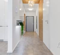ŠPIČKOVO KOMPLETNE ZARIADENÝ 2-izb. byt bez kompromisov - Chodba v 2-izbovom byte s keramickou podlahou, bielymi dverami a dekoratívnym svetlom.