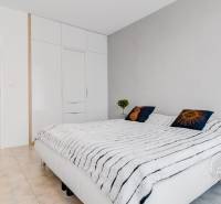 ŠPIČKOVO KOMPLETNE ZARIADENÝ 2-izb. byt bez kompromisov - Spálňa v 2-izbovom byte s bielym nábytkom a dekoratívnymi vankúšmi.