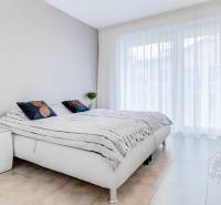 ŠPIČKOVO KOMPLETNE ZARIADENÝ 2-izb. byt bez kompromisov - Spálňa s bielou posteľou, nočnými stolíkmi a komodou v dvojizbovom byte.