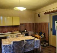 Predaj 4 izbový rodinný dom Šulekovo  - Kuchyňa v rodinnom dome s jedálenským stolom, kuchynskou linkou a chladničkou.