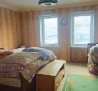 Predaj 4 izbový rodinný dom Šulekovo  - Izba v rodinnom dome s posteľou, stolom a hračkami, s dreveným dekorom podlahy.