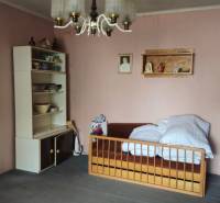 Predaj 4 izbový rodinný dom Šulekovo  - Izba s posteľou, policami s riadmi a závesným svietidlom v rodinnom dome.