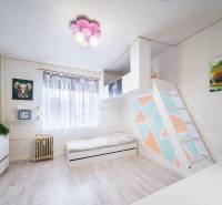 Kompletne zrekonštruovaný 3-izbový byt s balkónom – Rimavská Sobota - Detská izba v 3-izbovom byte s farebnou stenou a podlahou s dreveným dekorom.