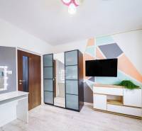 Kompletne zrekonštruovaný 3-izbový byt s balkónom – Rimavská Sobota - Farebná geometrická stena, zrkadlová skriňa, TV a stolík v 3-izbovom byte.