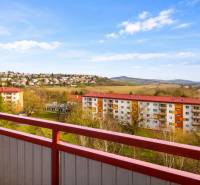 Kompletne zrekonštruovaný 3-izbový byt s balkónom – Rimavská Sobota - Výhľad z 3-izbového bytu na Rožňavskej ulici v Rimavskej Sobote so zeleňou a oblohou.