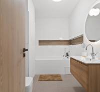 PRENÁJOM 3i byt s veľkorysou terasou a súkromím – Staré Grunty - Kúpeľňa s dreveným dekorom a oválnym zrkadlom v 3-izbovom byte.