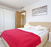 CHORVÁTSKO - VÝBORNÁ PONUKA! - 3-izbový apartmán - SUKOŠAN, Zadar - Svetlá spálňa s bielym nábytkom a červeným prehozom v 3-izbovom byte.