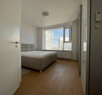 NUERA︱PANORAMA CITY- Veľký 3-izbový byt s výhľadom na hrad - Svetlá spálňa s posteľou a podlahou s dreveným dekorom v 3-izbovom byte.