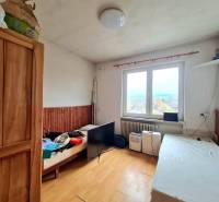 5.izb RD Čereňany pozemok 1028m - Interiér rodinného domu s podlahou s dreveným dekorom, posteľami a výhľadom z okna.