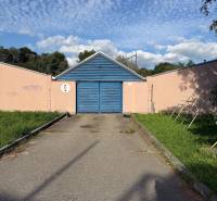 Garáž ul. Eisnerova, Devínska Nová Ves - Garáže na Eisnerovej ulici v Bratislave - Devínskej Novej Vsi, s modrou bránou a graffiti.