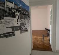 3,5 izb. byt v priamo centre Bratislavy na pešej zóne - Interiér 4-izbového bytu s podlahou s dreveným dekorom a umeleckou výzdobou na stene.