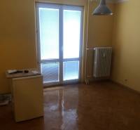 1-izb. byt na ul. Račianska, Nové Mesto s lodžiou - Izba v 1-izbovom byte s podlahou s dreveným dekorom a balkónovými dverami.