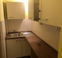 1-izb. byt na ul. Račianska, Nové Mesto s lodžiou - Kuchynský kútik s dreveným dekorom a bielymi skrinkami v 1-izbovom byte.