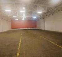 NA PRENÁJOM SKLAD 632 m2, KOŠICE - JUH - Priestor vo vnútri skladu s betónovou podlahou a bielymi oceľovými priehradovými stropmi.