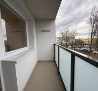 R E Z E R V O V A N Ý 3 izbový byt s balkónom , Košická, Komárno - Balkón 3-izbového bytu v Komárne na Košickej ulici s výhľadom na parkovisko a stromy.