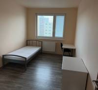 4-izb. byt, Wolkrova, Petržalka, 7.p./8 - Svetlá izba v 4-izbovom byte s posteľou, stolom a podlahou s dreveným dekorom.