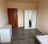 4-izb. byt, Wolkrova, Petržalka, 7.p./8 - Izba v 4-izbovom byte s podlahou s dreveným dekorom, skriňou a komodou.