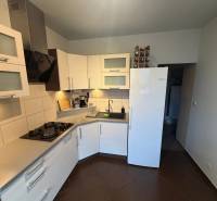 4-izb. byt, Wolkrova, Petržalka, 7.p./8 - Kuchyňa v 4-izbovom byte s bielymi skrinkami a tmavou podlahou s dreveným dekorom.