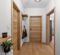 I Na predaj priestranný 2-izbový byt v Rovinke (City Park) - Chodba v 2-izbovom byte s drevenými dverami a podlahou s dreveným dekorom.