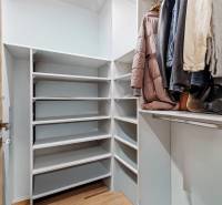 I Na predaj priestranný 2-izbový byt v Rovinke (City Park) - Šatník s policami a vešiakmi v 2-izbovom byte s podlahou s dreveným dekorom.