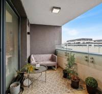 I Na predaj priestranný 2-izbový byt v Rovinke (City Park) - Balkón 2-izbového bytu v Rovinke na Slnečnicovej ulici s pohodlným sedením a rastlinami.