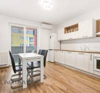 Na predaj moderný 2-izb. byt s loggiou vo Vrábľoch - Kuchyňa v 2-izbovom byte s bielymi skriňami a podlahou s dreveným dekorom.