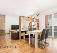 Na predaj moderný 2-izb. byt s loggiou vo Vrábľoch - Obývačka s jedálenským stolom v 2-izbovom byte, podlaha s dreveným dekorom, knižnica.