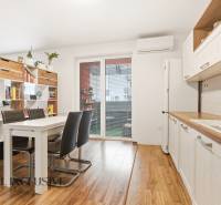 Na predaj moderný 2-izb. byt s loggiou vo Vrábľoch - Kuchyňa v 2-izbovom byte s jedálenským stolom a podlahou s dreveným dekorom.