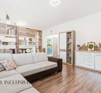 Na predaj moderný 2-izb. byt s loggiou vo Vrábľoch - Obývačka 2-izbového bytu s béžovou sedačkou a podlahou s dreveným dekorom.