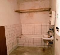 Rodinný dom Svätý Jur, centrum, pôvodný stav - Kúpeľňa v rodinnom dome s jednoduchou vaňou, umývadlom a dlaždicovými stenami.