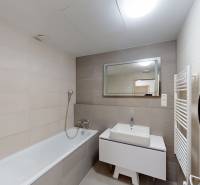 | Sky Park | zariadený 2i byt | panoramatický výhľad | garáž - Kúpeľňa v 2-izbovom byte so svetlými obkladačkami, vaňou a zrkadlom nad umývadlom.