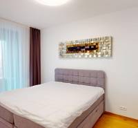 | Sky Park | zariadený 2i byt | panoramatický výhľad | garáž - Spálňa v 2-izbovom byte s podlahou s dreveným dekorom, posteľou a ozdobou na stene.