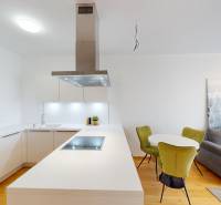 | Sky Park | zariadený 2i byt | panoramatický výhľad | garáž - Kuchyňa v 2-izbovom byte s bielou linkou, sedačkou a podlahou s dreveným dekorom.