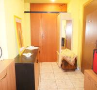 Veľký 1-izb. byt v tehlovom dome, Miletičova ul., Ružinov  - Vstupná chodba v 1-izbovom byte s hodinami, skriňami a dekoráciami.