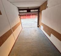 Garáž Bebravská ul., Vrakuňa s pozemkom - Interiér garáže na Bebravskej ulici vo Vrakuni, Bratislava, s otvorenými dverami na príjazdovej ploche.