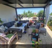ZATON - Apartmán so záhradou - na predaj  - Relaxácia na terase v Rekreačnom apartmáne s pohodlným sedením, kvetinovou výzdobou a stolom.