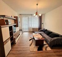 Pekný 2 izbový byt na prenájom - Malacky - Obývacia izba v 2-izbovom byte s podlahou s dreveným dekorom a pohovkou.