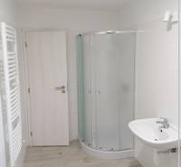 Na predaj kompletne zrekonštruovaný RD Bernolákovo -Trnavská - Kúpeľňa v rodinnom dome s bielym sprchovacím kútom a svetlou podlahou s dreveným dekorom.