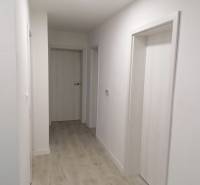 Na predaj kompletne zrekonštruovaný RD Bernolákovo -Trnavská - Chodba v rodinnom dome s bielymi stenami a podlahou s dreveným dekorom.