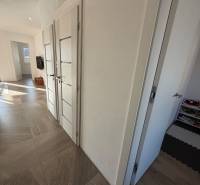 Novostavba rodinný dom Ludanice / REZERVOVANE - Chodba v rodinnom dome s hračkami a dlažbou.