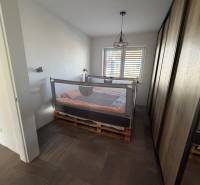 Novostavba rodinný dom Ludanice / REZERVOVANE - Spálňa v rodinnom dome s posteľou z paliet a veľkou skriňou.