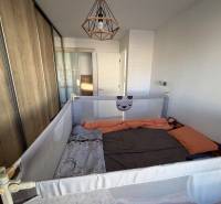 Novostavba rodinný dom Ludanice / REZERVOVANE - Izba s detskou ohradou a vstavanou skriňou v rodinnom dome, podlaha s dreveným dekorom.