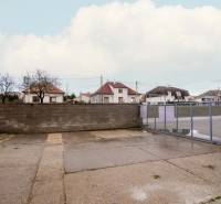 Prenájom haly / obchodno-skladových priestorov – Šenkvice, Nádražná ul - Exteriér na Nádražnej ulici v Šenkviciach, vedľa skladov a hál s oceľovou bránou.