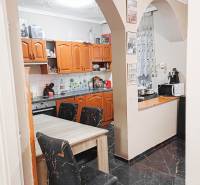 Rodinný dom, Maďarsko, obec Vizsoly - Kuchyňa v rodinnom dome s oblúkovým vstupom, drevené skrinky a čierne podlahy.