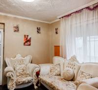 Rodinný dom, Maďarsko, obec Vizsoly - Obývacia izba rodinného domu s ornamentálnym nábytkom a fotografiami na stenách.