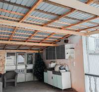 Rodinný dom, Maďarsko, obec Vizsoly - Rodinný dom: Prístrešok s kovovou strechou, ratanové kreslá, umelé stromčeky, úložné priestory.