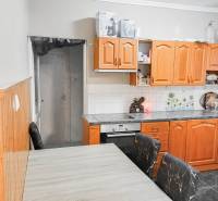 Rodinný dom, Maďarsko, obec Vizsoly - Kuchyňa v rodinnom dome s drevenými skrinkami a stropným obkladom.